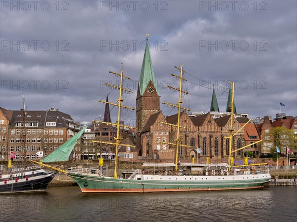 Sailing ship "Alexander von Humboldt" on the banks of the Weser with the red brick buildings of the old town in the background