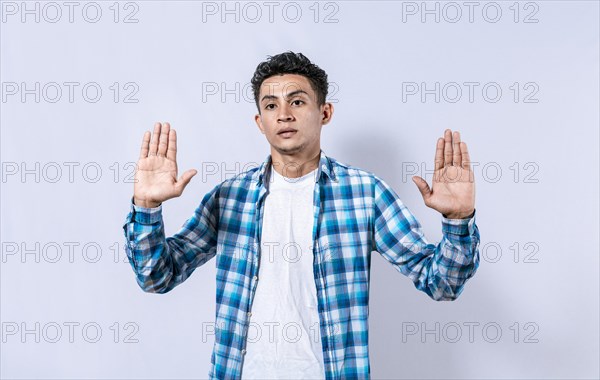 Scared and horrified man with raised palms