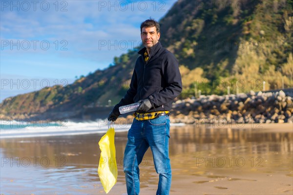 Volunteer portrait collecting garbage and plastic on the beach. Ecology concept