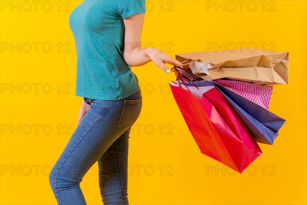 Unrecognizable person with colored shopping bags at sales