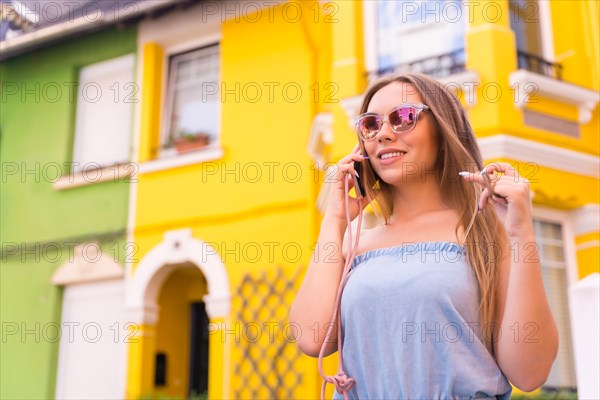 Portrait of young blonde tourist talking on the phone