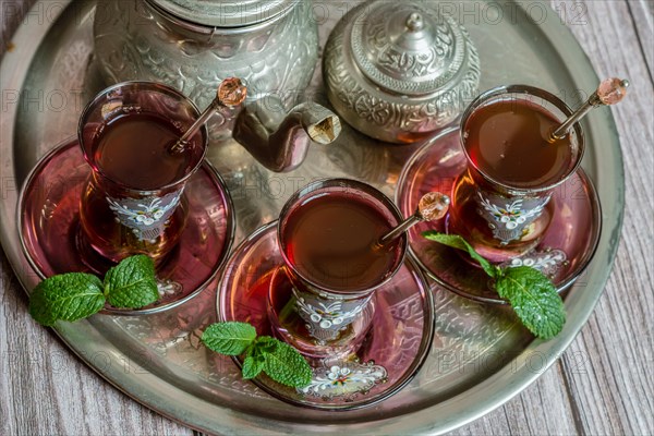 Tray with glasses and serving pitcher of authentic Moorish tea ready to drink with mint leaves