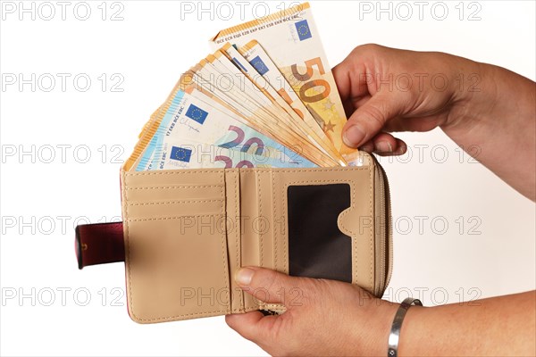 Woman's hands taking euro banknotes out of her wallet with white background and copy space