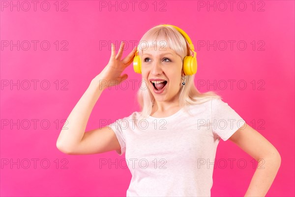 Blonde caucasian girl in studio on pink background
