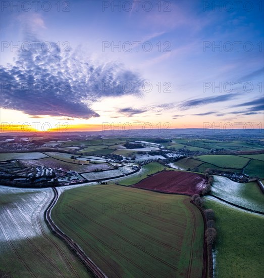 Sunset over Fields and Farms shrouded in frost from a drone