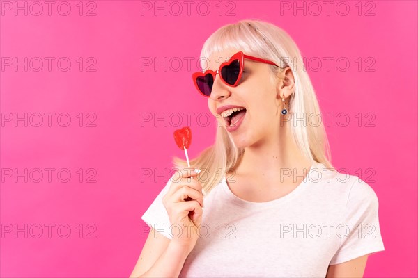 Blonde caucasian girl in studio on pink background