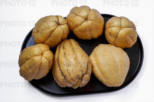 Close-up of chayotes isolated on a white background on a black platter