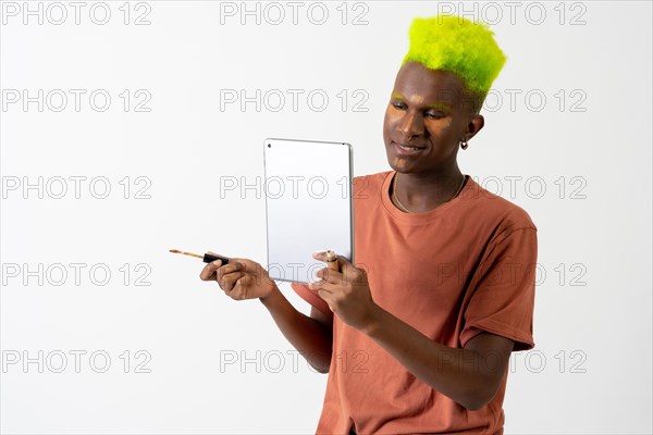 A gay black ethnic man putting on makeup