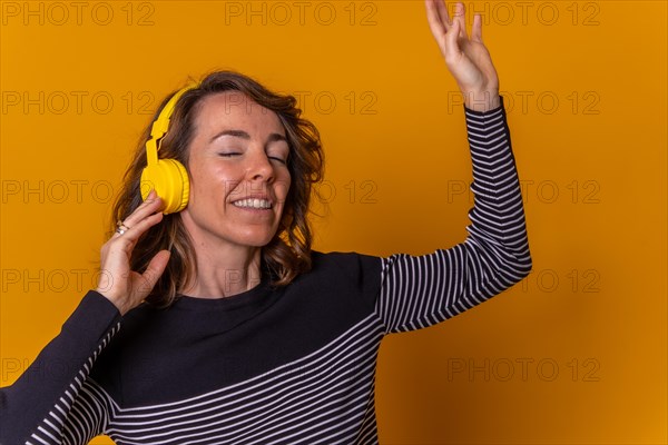 Caucasian girl listening to streaming music and smiling and dancing with her phone