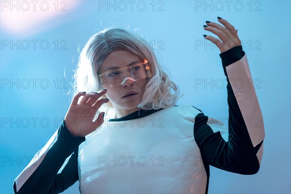 Woman looking through the illuminated futuristic glasses