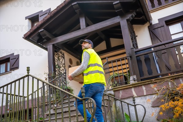 A young delivery man in a protective uniform at the delivery of the online order