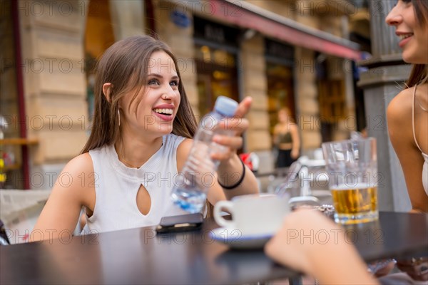 Woman with friends having something one afternoon on a cafeteria terrace with her friends