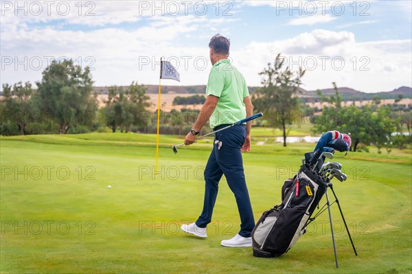 Caucasian professional golf player on the green preparing for the shot