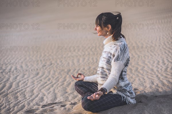 Side view of a woman clasping hands at the beach. Namaste pose