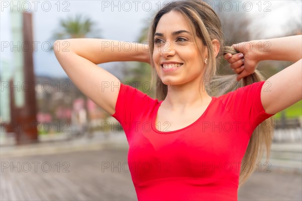 Fit woman in red clothes doing sports in the city in spring