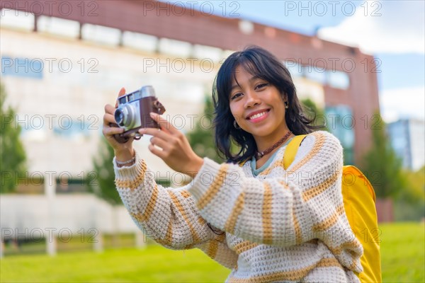 Asian young woman photography with a vintage photo camera visiting a city park