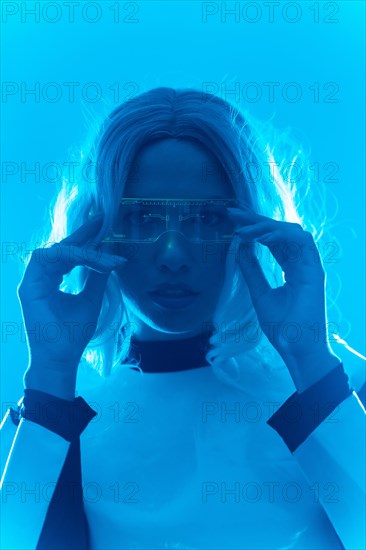 Young woman with futuristic suit and glasses with blue led lights