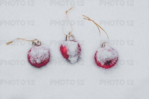 Concept of the postcard with Christmas baubles covered with snow