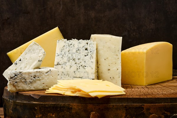 Assortment of different types of cheese on wooden block