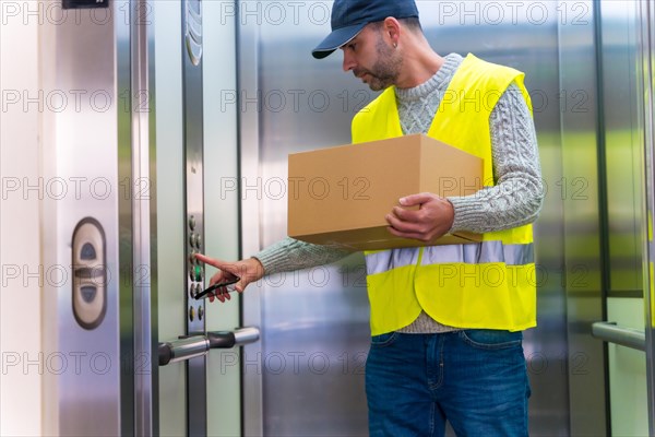 Young delivery man in protective uniform at online order delivery