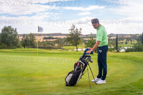 Caucasian professional golf player on a golf course on the green preparing for the shot