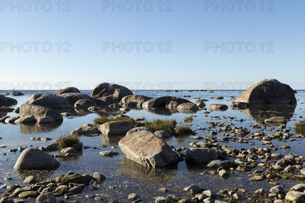 Erratic blocks in the water against a blue sky at Lahe Pank beach