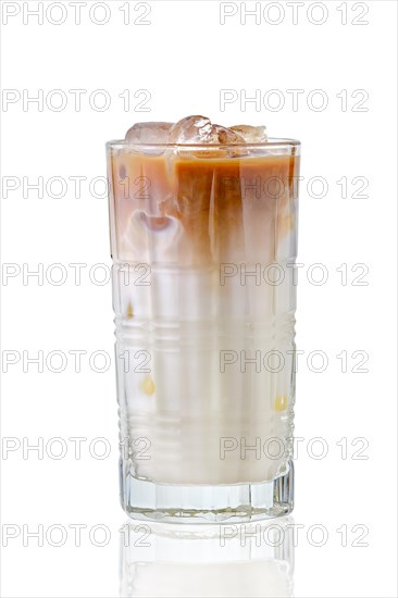 Iced coffee with milk in tall facetted glass with reflection