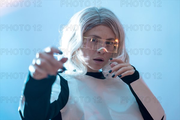 Woman looking through the illuminated futuristic glasses