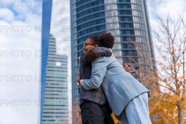 Middle-aged multi-ethnic businesswomen and executives hugging in good work environment