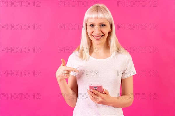 Blonde caucasian girl in studio on pink background