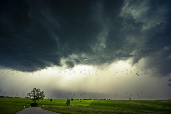 Road and meadows with thunderstorm sky in the background