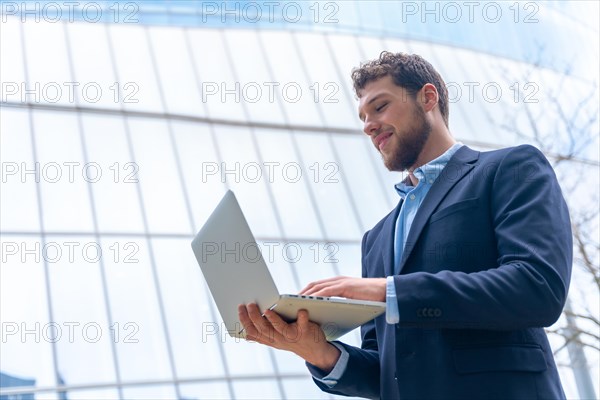 Young businessman or finance man looking at computer outside office