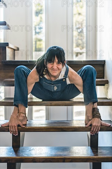 A woman doing stretching exercises on the stairs of her home. Wellbeing concept