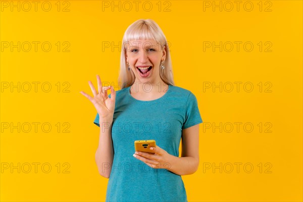 Smiling ok gesture with phone