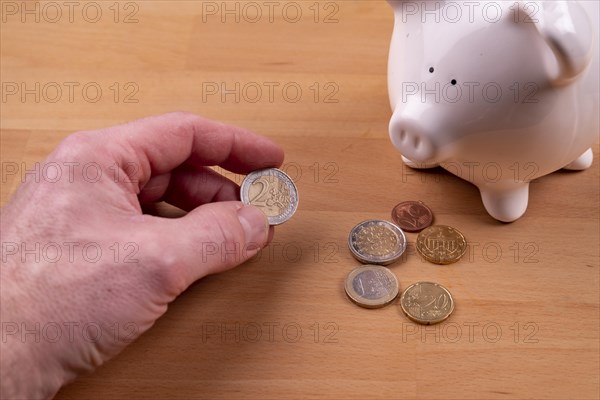 White piggy bank with some euro coins