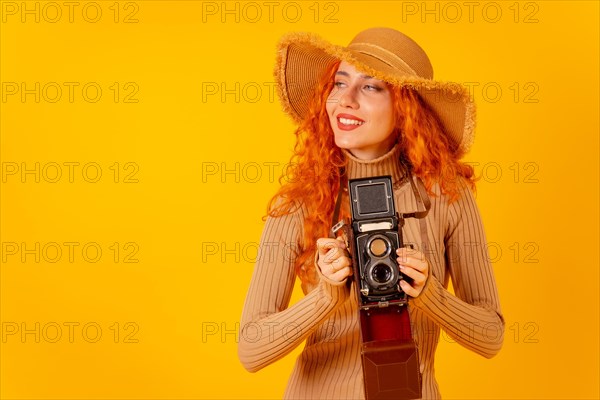 Red-haired woman tourist on a yellow background