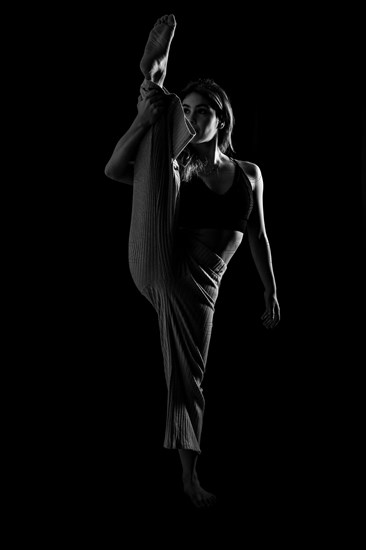 Young dancer in studio photo session with a black background