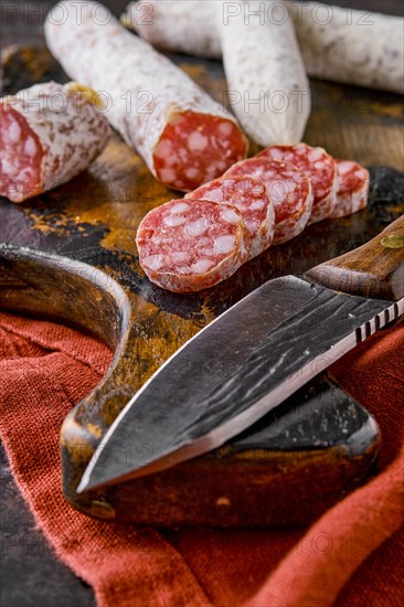 Fermented air-dried salami on wooden cutting board cut on slices