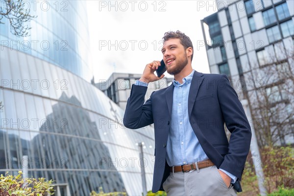 Male businessman or entrepreneur talking on the phone outside the office