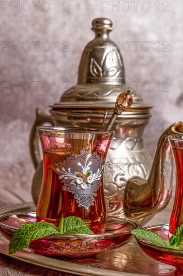 Tray with glasses and serving pitcher of authentic Moorish tea ready to drink with mint leaves