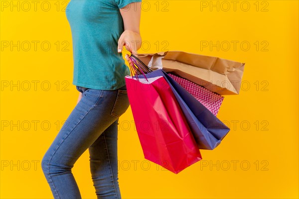 Unrecognizable person with colored shopping bags on sale