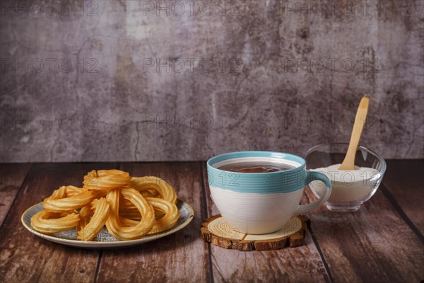 Hot chocolate with churros in a white and blue cup