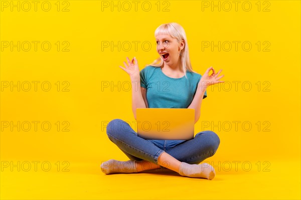 Smiling sitting with a laptop doing ok