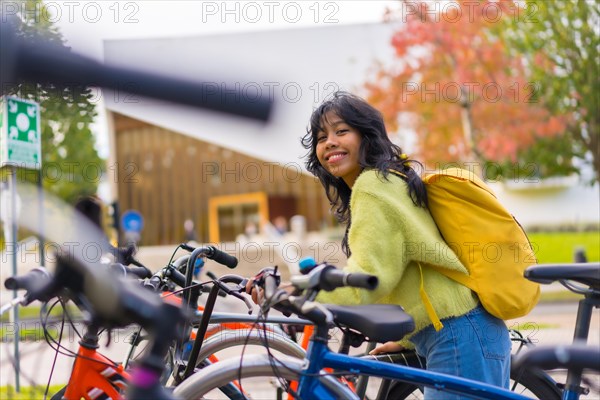 Portrait of asian female student parking the bike in college campus