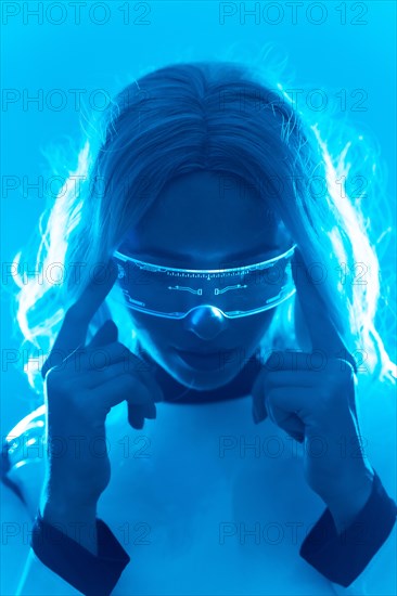 A woman in a futuristic suit and glasses with blue lights