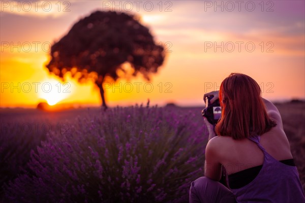 A woman at sunset in a lavender field with purple flowers