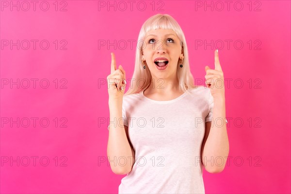 Blonde caucasian girl on pink studio background