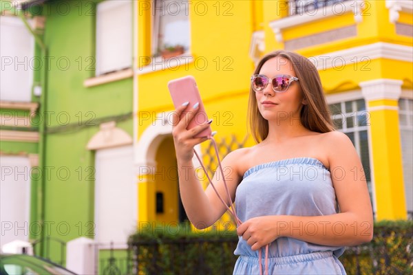 Portrait of young blonde tourist voice message with phone