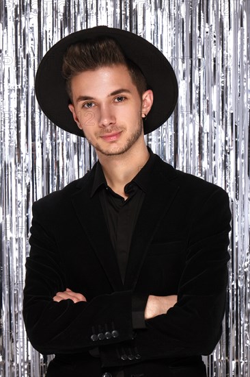 Young attractive man in a New Year's look. The photo was taken in a studio in a festive decor