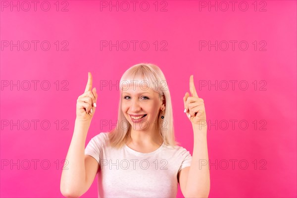 Blonde caucasian girl studio shot on pink background